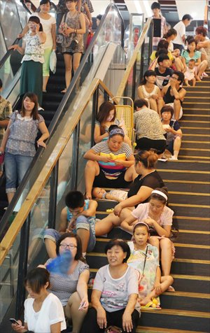 Residents sit in line on the staircase of a supermarket and get free airconditioning in Xuchang, Henan Province on Sunday, when the temperature in the city hit 36 C. Photo: CFP