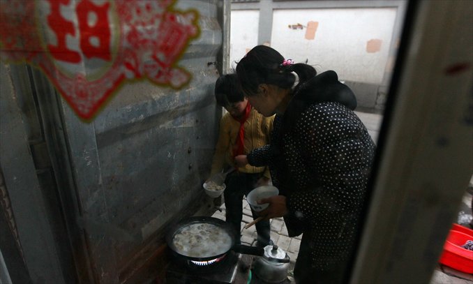 Wu's wife dishes out dumplings to her son outside their home. Photo: Yang Hui/GT