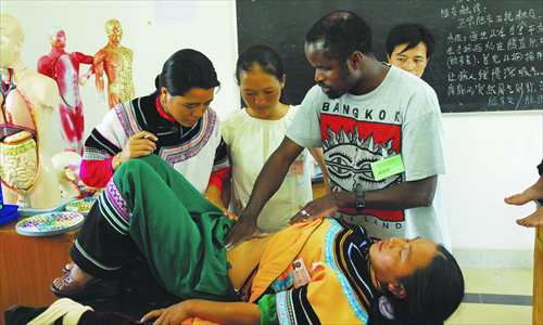 Diarra Boubacar teaches local doctors in Honghe, Yunnan Province how to treat a patient. Photo: Courtesy of Diarra Boubacar