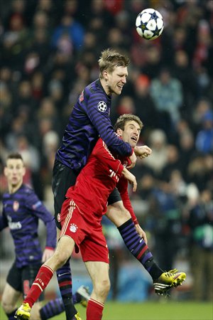 Per Mertesack (left) of Arsenal and Thomas Mueller of Bayern Munich comepte for the ball on Wednesday. Photo: CFP