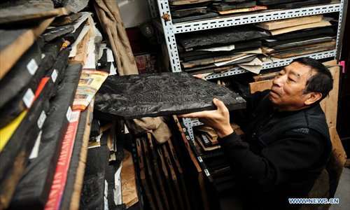 Huo Qingyou, a woodcut new year picture artist, takes out a wooden type to make ink rubbings in Yangliuqing town, north China's Tianjin Municipality, Dec. 28, 2012. In Yangliuqing, dubbed 