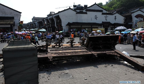 Photo taken on Aug. 12, 2012 shows the scene of a decorated archway toppling accident in Hefang Street, a busy commercial area and tourism destination in Hangzhou, capital of east China's Zhejiang Province. Two people were killed and several others injured after a decorated archway, or pailou, suddenly toppled down Sunday morning in Hangzhou. Photo: Xinhua