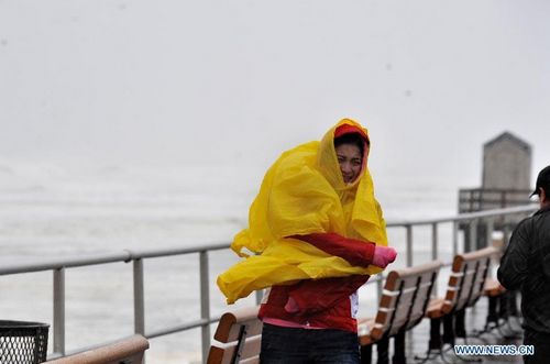 A man watches tides along the beach at the Long Island in New York, the United States, on October 29, 2012. Hurricane Sandy, a massive storm described by forecasters as one of the largest ever that hit the United States, is making its way towards the population-dense East Coast. Michael Bloomberg, mayor of New York, has asked the public to stay at home when Sandy slams the city. Nearly 10,000 flights have been canceled for Monday and Tuesday by airlines bracing for Hurricane Sandy. Photo: Xinhua