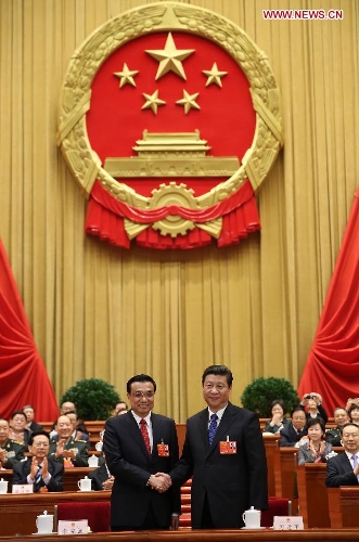 Xi Jinping (R) shakes hands with Li Keqiang at the fifth plenary meeting of the first session of the 12th National People's Congress (NPC) at the Great Hall of the People in Beijing, capital of China, March 15, 2013. Li Keqiang was endorsed as the premier of China's State Council at the meeting here on Friday. (Xinhua/Lan Hongguang)