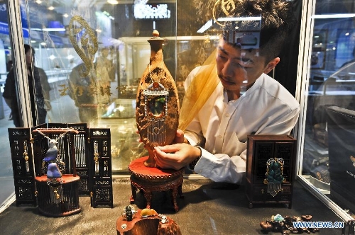 An exhibitor places an ornament at the 2013 Beijing Summer Jewelry Show in Beijing, capital of China, July 4, 2013. (Xinhua/Wang Jingsheng)