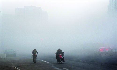 People ride to work and school amid the hazy weather in Beijing on Sunday morning. Photo: CFP