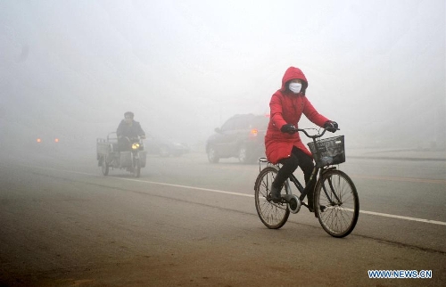 A citizen rides a bicycle amid fog and smog in Baoding, north China's Hebei Province, Feb. 28, 2013. The province was hit by heavy fog on Feb. 28 morning and the local meteorological bureau has issued an orange alert for the fog. (Xinhua/Zhu Xudong) 