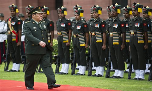 Chinese Defense Minister Liang Guanglie inspects a guard of honor after a meeting with Indian Defence Minister A. K. Antony in New Delhi on Tuesday. Joint military exercises between India and China will be resumed after a four-year gap. Photo: AFP
