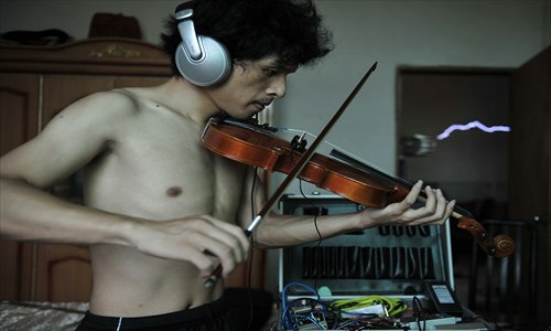 Wang Zengxiang, founder and leader of the band, experiments with a violin in his home. Photo: CFP