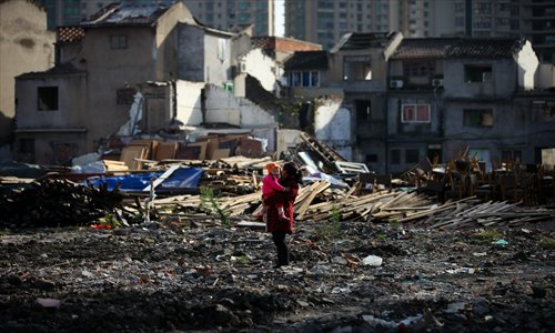 A mother and baby survey the ruins of another building. Photo: Cai Xianmin/GT