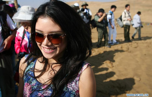 A contestant with sunglasses smiles during the Miss World 2012, a beauty contest, in Xiangshawan scenic area in Ordos, north China's Inner Mongolia Autonomous Region, July 31, 2012. Contestants from 125 countries and regions will compete in the event which lasts from July 24 to August 18. Photo: Xinhua