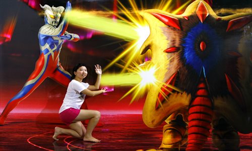A visitor poses in front of a 3D image of the Japanese cartoon character Ultraman Thursday at Shanghai World Financial Center. The center is hosting an exhibition of 35 pieces of 3D art featuring famous Japanese animated characters. Photo: Yang Hui/GT