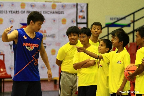 A player from the Shanghai Sharks high-fives a Filipine boy during a basketball clinic in Pasig City, the Philippines, May 5, 2013. Yao and his Shanghai Sharks are in Manila on a friendly visit. They will attend two exhibition games respectively with the Smart Gilas Team and the Philippine Basketball Association (PBA) Selection. (Xinhua/Rouelle Umali) 