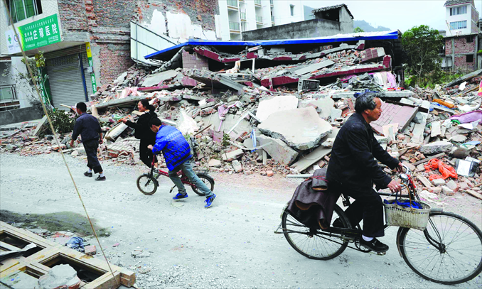 People pass by destroyed houses in Lingguan, Baoxing county on Sunday. Photo: Li Hao/GT