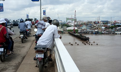 Passersby watch the new Chroy Changvar Bridge, which was funded by China, in Phnom Penh, Cambodia on August 15, 2011. Investments from China and other countries are very important to spur Cambodia's economy, Heng Samrin, president of Cambodia's National Assembly, said Monday. Photo: CFP