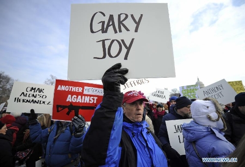 People hold signs with names of gun violence victims in front of the Capitol Hill during a march in Washington D.C., capital of the United States, Jan. 26, 2013. Thousands of people, including family members of victims and survivors of shootings at Virginia Tech University, Sandy Hook elementary school and others, took part in a march for stricter gun control laws here on Saturday. (Xinhua/Zhang Jun) 