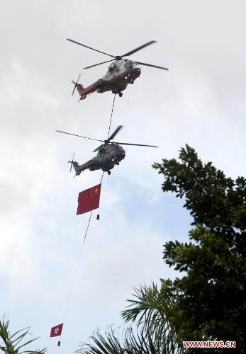 Helicopters carrying Chinese national flag and the flag of the Hong Kong Special Administrative Region fly over Golden Bauhinia Square during the flag-raising ceremony in Hong Kong, south China, July 1, 2013. A flag-raising ceremony is held in Hong Kong Monday to celebrate the 16th anniversary of Hong Kong's return to the motherland. (Xinhua/Lui Siu Wai) &nbsp;