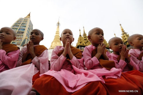 Novices pay homage on the first day of Myanmar new calendar year at the world-famous Shwedagon Pagoda in Yangon, Myanmar, April 17, 2013. On Myanmar new year's day, people in the country used to perform meritorious deeds and Buddhists, who account for the majority of the people, usually go to the pagodas, monasteries and meditation centers where they practice meditation. (Xinhua/U Aung)&nbsp; 
