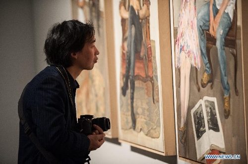 A visitor looks at a painting by Chen Danqing during the 