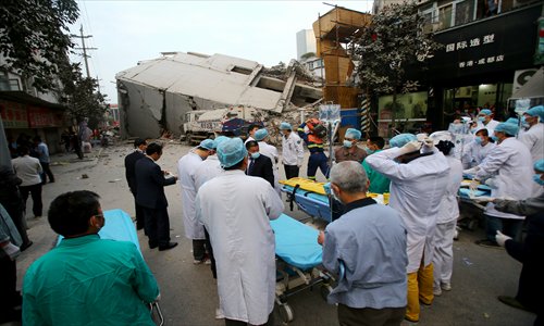 Medical staff wait outside the collapsed Huaxie Cinema in Chengdu, Sichuan Province, Thursday afternoon. The 28-year-old cinema was being demolished to make way for urban renovation when the accident happened. No casualties were reported as of early Thursday as rescuers are still searching for survivors. Photo: CFP