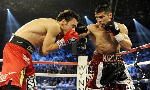 Julio Cesar Chavez Jr. (left) takes a punch from Sergio Martinez in the fourth round of their fight. Photo: AFP 