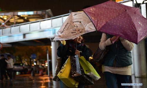 A pedestrian tries to hold her umbrella against strong winds in Beijing, capital of China, November 3, 2012. The cold wave that has swept northwestern China is moving eastward and is expected to bring blizzards to parts of northern China, the National Meteorological Center (NMC) forecast on Saturday. Heavy snow will hit Inner Mongolia, Hebei, Shanxi and the mountainous areas in western Beijing, according to a posting on the NMC website. The NMC has issued a blue warning on blizzards for Saturday, the lowest level in disaster alarm after yellow, orange and red. Photo: Xinhua