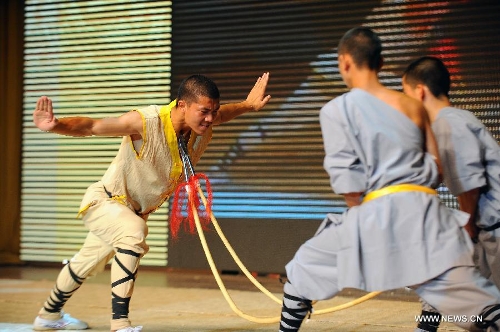 A performer of the Yandong Shaolin Kungfu troupe makes double spears crooked by resisting spear heads during a performance held at the Worker's Cultural Palace, Taiyuan, capital of north China's Shanxi Province, July 6, 2013. The martial art troupe have their performers trained in the renowned Shaolin Temple, and staged performances worldwide in the hope of promoting Shaolin-style martial arts and Chinese culture. (Xinhua/Fan Minda)&nbsp; 