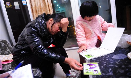 The family of Yuanyuan, the toddler beaten by a 10-year-old girl who fell from the 25th-floor balcony of a Chongqing apartment building, share their photo album with photographers on December 5. Photo: CFP