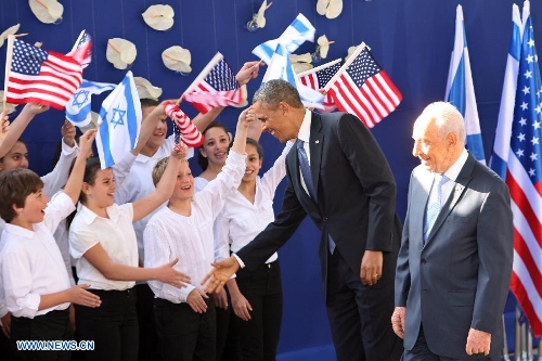 U.S. President Barack Obama greets Israeli children before meeting with Israeli President Shimon Peres (R) at the president's residence in Jerusalem on March 20, 2013. Obama arrived in Israel on Wednesday, starting his first visit as U.S. president to the country. (Xinhua/Muammar Awad) 