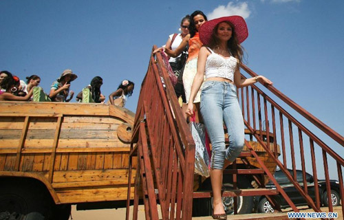 Contestants arrive at Xiangshawan scenic area to attend Miss World 2012, a beauty contest, in Ordos, north China's Inner Mongolia Autonomous Region, July 31, 2012. Contestants from 125 countries and regions will compete in the event which lasts from July 24 to August 18. Photo: Xinhua