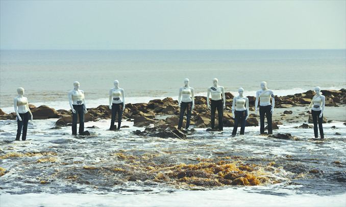 Several models, wearing trousers made by global fashion leaders alleged to have been using harmful substances in their clothing process, are set up outside a sewage drain exit at the estuary of Hangzhou Bay on December 4. Photo: Courtesy of Greenpeace