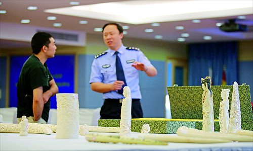 A Hongkou district police officer shows off the ivory carvings seized yesterday after police busted an illegal trade syndicate in Shanghai. Photo: Cai Xianmin/GT