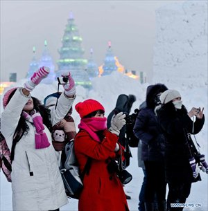 Tourists take photos of snow sculptures at the 29th Harbin International Ice and Snow Festival in Harbin, capital of northeast China's Heilongjiang Province, December 23, 2012. The festival kicked off at the Harbin Ice and Snow World on Sunday. Photo: Xinhua