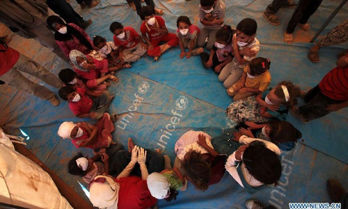 Syrian refugee children play games in a tent at the Zaatari camp for Syrian refugees, 15 kilometres (nine miles) from the kingdom's northern city of Mafraq, near the border with Syria, on August 11, 2012. There are now about 3,000 Syrians taking shelters in the desert Zaatari refugee camp that was opened last month to alleviate the humanitarian crisis. Photo: Xinhua