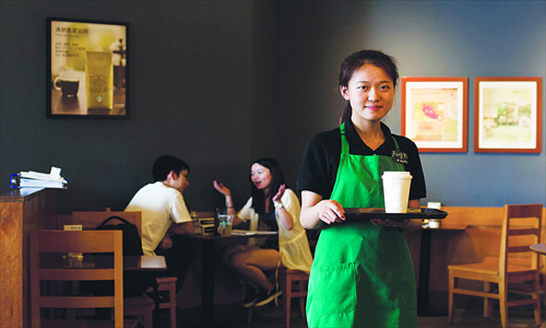 Main: Liu Liu, 23, serves coffee at a coffee shop in Ningbo, Zhejiang Province on May 28. She receives a monthly salary of 3,000 yuan. Photo: CFP