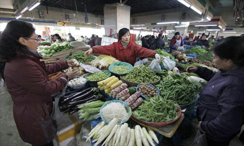Consumers buy vegetable at a market in Nanjing, capital of east China's Jiangsu Province, December 9, 2012. China's consumer price index (CPI), a main gauge of inflation, grew 2 percent year on year in November, the National Bureau of Statistics announced Sunday. The inflation rate increased from a 33-month low of 1.7 percent in October as food prices increased. Photo: Xinhua