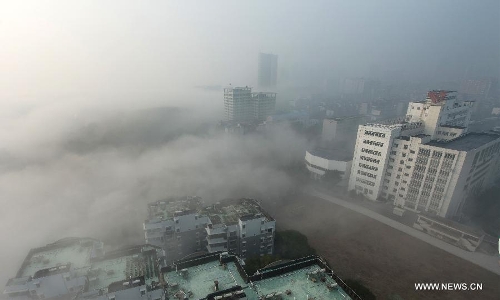 Buildings are seen amid dense fog in Wuhan City, capital of central China's Hubei Province, Jan. 12, 2013. (Xinhua/Cheng Min)  