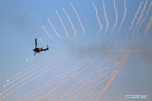 A U.S. helicopter fires during the Eager Lion military exercise, at the Quweira city, 290km south of Amman, Jordan, June, 19, 2013. The 12-day exercise involves combined air, land and sea maneuvers across Jordan. Along with Jordan and the U.S., the exercise brings together some 8,000 personnel from 19 Arab and European nations to train on border security, irregular warfare, anti-terrorism and counterinsurgency. (Xinhua/Mohammad Abu Ghosh) 