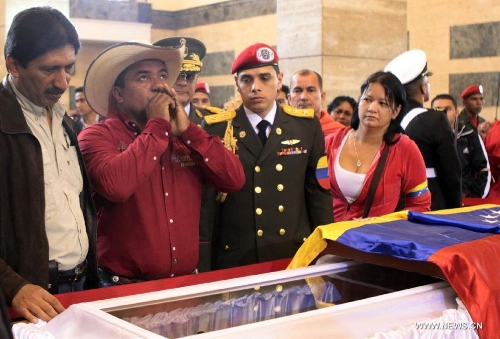 &nbsp;Image provided by the Presidency of Venezuela shows residents react as visiting the coffin keeping the remains of late Venezuelan President Hugo Chavez, at the Military Academy of Venezuela in the city of Caracas, capital of Venezuela, on March 10, 2013. Venezuela's National Electoral Council (CNE) announced on Saturday after a special meeting of its Board of Directors that the presidential elections will be held on April 14.(Xinhua/Presidency of Venezuela) 
