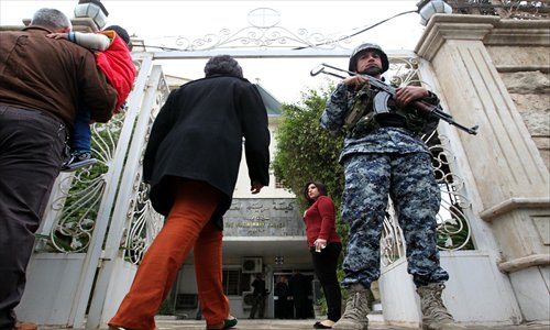 An Iraqi soldier stands guard outside the Virgin Mary Church in the Karrada neighborhood of Baghdad as Iraqi Christians arrive to celebrate Christmas mass on Tuesday. Photo: AFP