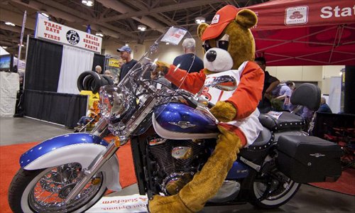 A costumed mascot poses for photos with a motorcycle during the 2012 Toronto Motorcycle Show at the Metro Toronto Convention Centre in Toronto, Canada, December 8, 2012. The three-day event displays hundreds of new 2013 motorcycles, scooters from the world's top manufacturers from December 7 to 9 this year. Photo: Xinhua