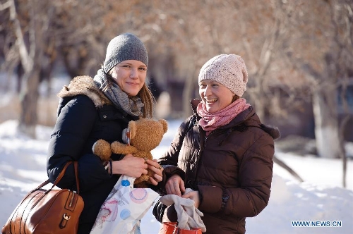 Two women talk in a street in Chelyabinsk, Russia, Feb. 16, 2013. Life in Russia's Chelyabinsk Region returns to normal after Friday's meteorite explosion as residents start to cover smashed windows with Cellophane sheets to keep warm. About 1,200 people have been known injured and many buildings damaged since a meteor exploded on Friday morning, raining fireballs over Russia's central Urals region, the Interior Ministry said. (Xinhua/Jiang Kehong)