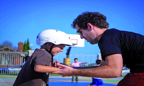 James Herrmann guides a student learning to balance on a skateboard. Photo: Courtesy of James Herrmann