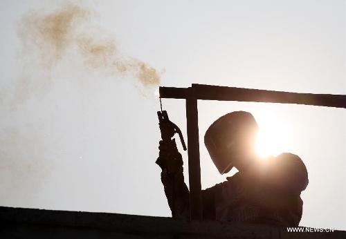 A fitter works at a construction site in southwest China's Chongqing Municipality, June 18, 2013. The highest temperature in many parts of China reached 37 degrees centigrade Wednesday. (Xinhua/Luo Guojia)