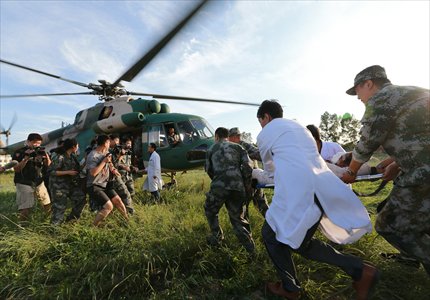Rescuers carry injured earthquake survivors to a military helicopter in Minxian county, Gansu Province Tuesday. The injured were being transferred to hospitals in the provincial capital Lanzhou after having had surgery. By Wednesday afternoon, the 6.6-magnitude quake had killed 95 and injured 1,366. Photo: CFP