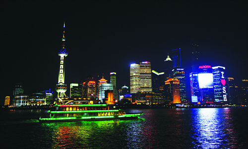 A brightly-illuminated tourist boat cruises along the Huangpu River as the east bank skyscrapers dazzle in the background with a variety of spectacular lighting designs. Photo: Cai Xianmin/GT