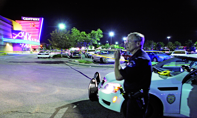 A police officer talks on his radio outside the Century 16 movie theater at the Aurora Mall in  suburb of Denver, Colorado, where at least 12 people were killed and many more injured from a shooting spree on Friday. Photo: IC
