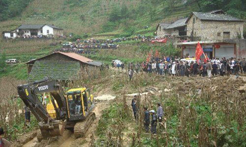 Rescuers search at the landslide site in the village of Zhenhe, located in Yiliang County of Zhaotong City in southwest China's Yunnan Province, October. 4, 2012. Nineteen people, including 18 students, were buried in a landslide here on Thursday. Eighteen people have been confirmed dead and one people remain missing. Photo: Xinhua