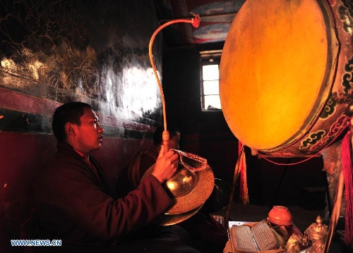 A lama chants scriptures at the Naimu Temple in Zharen Town of Anduo County, southwest China's Tibet Autonomous Region, June 26, 2013. The Naimu Temple, built in 1840, belongs to the Gelugpa sect of the Tibetan Buddhism. (Xinhua/Liu Kun)