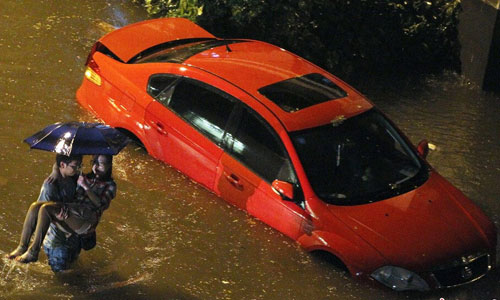 A man carrying his girlfriend wades in deep stagnant water on the road. Photo:Chinanews.com
Beijing suffered the strongest rainfall since 61 years on July 21 2012. Water made traffic hindered, cars flooded, and streets become rivers. Photo: Chinanews.com